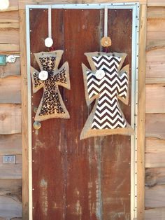 two ornaments hanging on the side of a wooden door