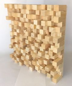 a large wooden block sculpture sitting on top of a white surface