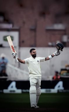 a man holding a cricket bat and ball in his right hand while standing on a field