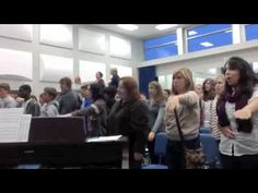 a group of people standing in front of a piano