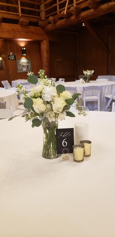 Mixed white and green centerpiece in 8 inch tall vase Simple Wedding Centrepieces Round Tables, White Roses Table Centrepiece, Eucalyptus And Rose Centerpiece, White Rose And Eucalyptus Centerpiece, Simple White Rose Centerpiece, Roses And Eucalyptus Centerpiece, Simple White Flower Centerpieces, Simple Rose Centerpiece, White Rose Wedding Centerpieces