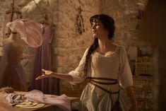 a woman dressed in medieval clothing standing next to a table