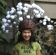 a woman wearing a t - shirt that says blow me on it with cotton balls all over her head