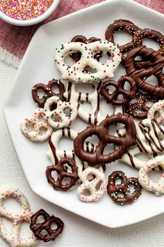 a white plate topped with chocolate covered pretzels and sprinkles