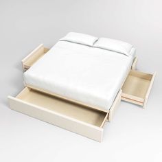 a white bed with two drawers underneath it