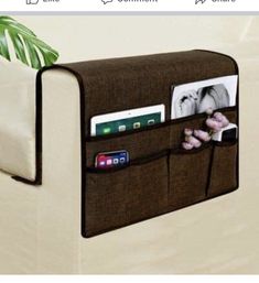 a white couch with a brown pocket holding photos and other items on it's side