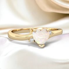 Delicate and dainty, this 14K Gold ring is a lovely way to express the love within you. A heart shaped multicolored opal is the focus of this ring, with two sparkling diamonds. It creates an elegant look that is not overstated, and is beautiful on the hand. It is perfect as an everyday ring and an excellent choice for a promise ring as well.  Gem: Genuine Opal Metal: solid 14K Gold Diamonds: genuine SI2 diamonds Free gift packaging is included with every order. Elegant Heart-shaped Opal Ring For Anniversary, Opal Heart Ring, Heart Promise Rings, Gold Promise Rings, Diamond Free, Everyday Rings, 14k Gold Ring, Pink Pearl, Multi Stone Ring