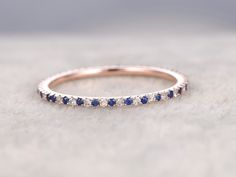 a white gold band with blue sapphire stones on it, sitting on top of a table