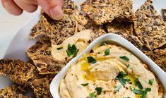 a white plate topped with crackers and hummus