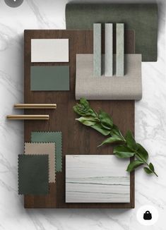 an assortment of different colors and materials on top of a wooden board with plants in the middle