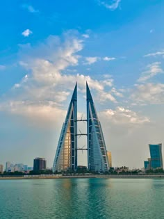 two tall buildings sitting on top of a large body of water