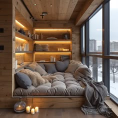 a living room filled with lots of furniture next to a large glass window covered in snow