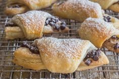 chocolate croissants on a cooling rack with powdered sugar