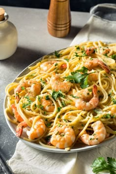 a plate of pasta with shrimp and parsley