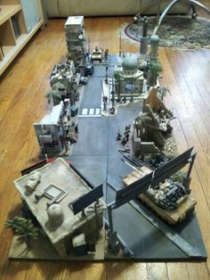 a group of toy army vehicles and tanks on the floor in a living room with wooden floors