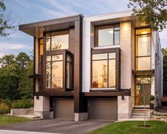 a two story house with large windows and lots of grass