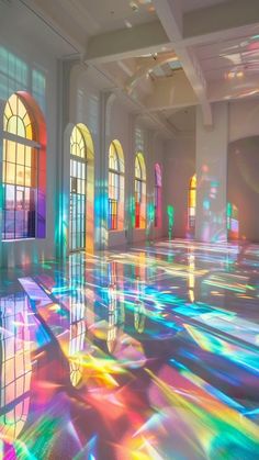 an empty room with stained glass windows and rainbow colored light coming from the windows on the floor