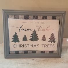 a framed sign that says farm fresh and christmas trees on the side of a table