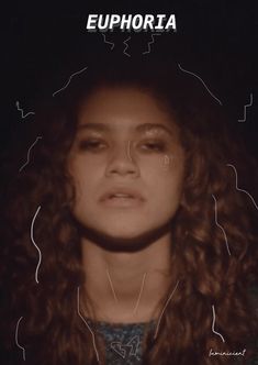 a woman with curly hair is looking at the camera and has her eyes closed in front of her face