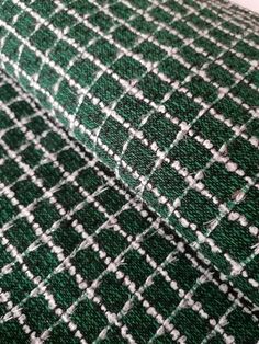 the green and white plaid fabric is very close up on this piece of cloth that has been