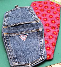 two jeans are sitting next to each other on a green surface with red and yellow flowers