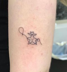 a small star with a balloon tattoo on the arm