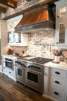 a stove top oven sitting inside of a kitchen next to white cupboards and drawers