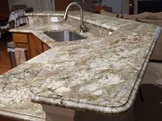 a kitchen counter top with a sink and faucet in the middle of it