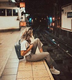 a woman sitting on top of a train platform