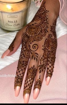 henna tattoo on the hand with candles in the background