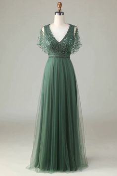 a green dress on a mannequin with sequins and beaded detailing