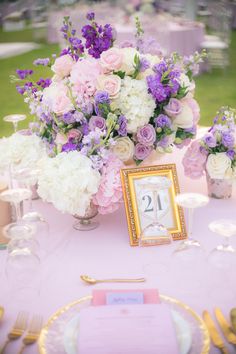 the table is set with purple and white flowers