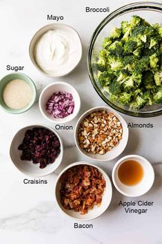 the ingredients to make broccoli salad laid out in bowls on a white surface