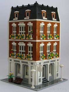 a building made out of legos with flowers on the windows and balconies