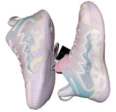 a pair of white and pink sneakers with unicorns on them are facing each other