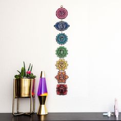 there are seven chakras on the wall next to some plants and vases