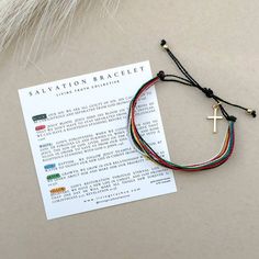 the salvation bracelet is on top of a piece of paper with a cross charm attached to it