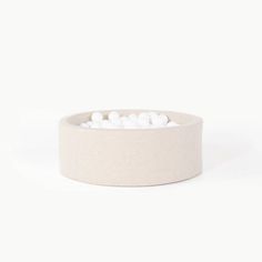 a white bowl filled with marshmallows sitting on top of a table next to a wall