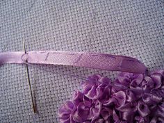 a close up of a piece of cloth with flowers on it and a sewing needle