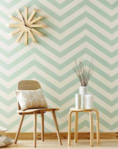 two chairs and a table in front of a wall with a clock on the wall