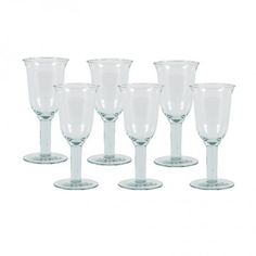 six clear goblets sitting next to each other