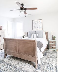 a bedroom with a bed, dresser and ceiling fan in the middle of the room