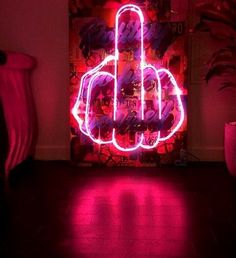 a pink neon sign in the middle of a room with red light coming from it