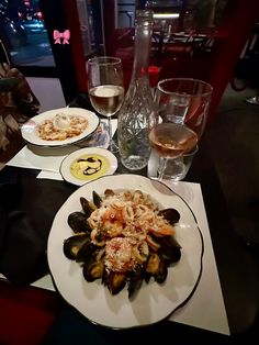 a table topped with plates of food and glasses of wine