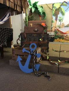 an anchor is chained to the ground next to some trunks and other things on display