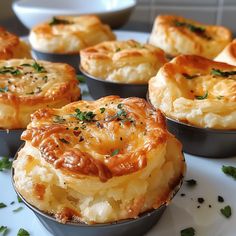 several small pies on a white plate with parsley sprinkled around them