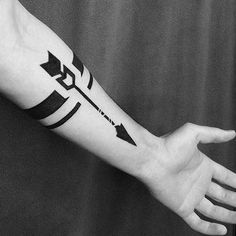 a black and white photo of a person's arm with an arrow tattoo on it