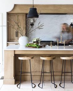 an image of a kitchen with two stools in front of the counter and one on the wall