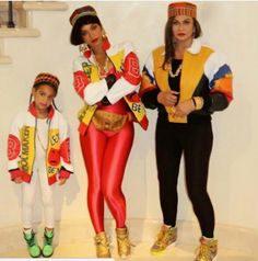 two women and a child are dressed up in costumes that look like they're from the 80s