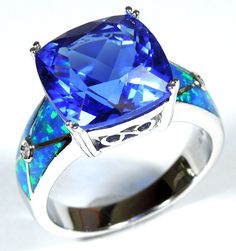 "Exquisite brand new high quality silver ring with lab created blue Inlay Fire Opals and 12mm (almost 1/2\")  faceted cushion cut Tanzanite, and two round Cubic Zirconia accent stones set on solid 925 sterling silver and stamped with 925. Our silver is genuine 925 sterling silver and Rhodium plated for better quality and prolonged shine.  You will receive the item in a gift box. Thanks for looking and check out more items in my Etsy shop for more great items and deals! https://www.etsy.com/shop/925usa Payment: We accept all major credit cards through direct check out and Paypal. New Mexico residents have to pay sales tax. Payments must be made within 3 days of purchase or the purchase will be canceled. Shipping: SHIPPING IS FREE FOR ALL USA DOMESTIC SHIPMENTS! For international shipments, Elegant Blue Opal Ring With Accent Stones, Blue Opal Ring For Formal Occasions, Formal Blue Opal Ring Fine Jewelry, Formal Blue Opal Fine Jewelry Ring, Blue Fire Opal, Woman Ring, Blue Fire, Pretty Rings, Tanzania